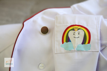 A close-up of a logo on the left sleeve pocket of a white lab coat, featuring a design suitable for dentist professionals.