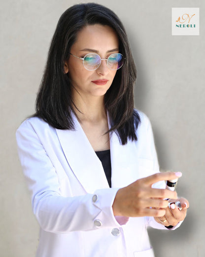 Medical nurse in uniform and eyeglasses reading the label of a clear injection liquid bottle handed to her