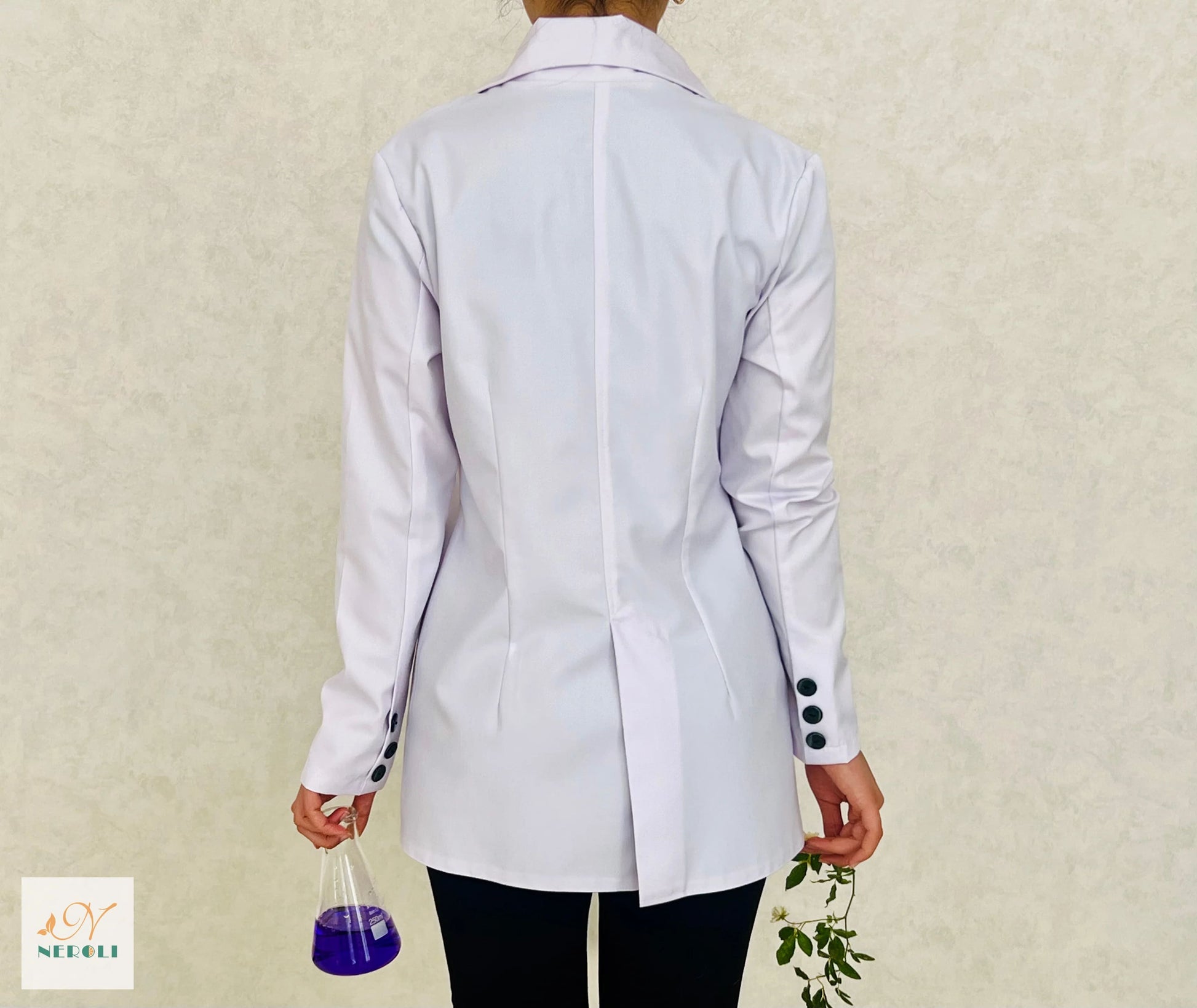 A white peak lapel coat worn by a laboratory professional, with a center vent and smooth fabric, as seen from the back.